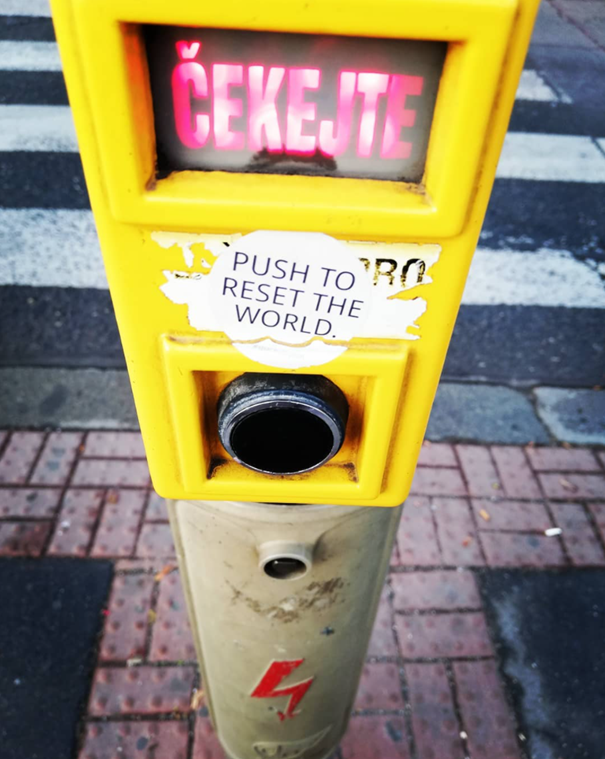 Push to reset the world, sticker art at a pedestrian crossing(Prague, CZ).