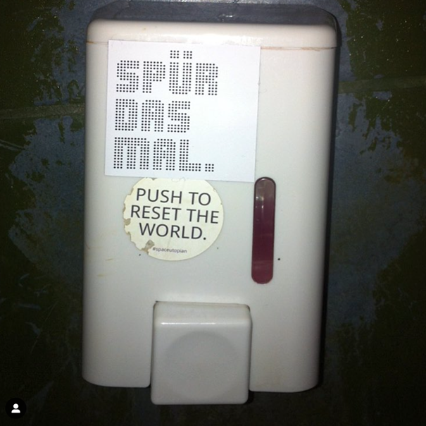Push to reset the world, sticker art on a soap dispenser (Berlin, DE).